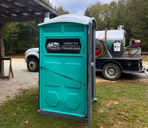 Teal restroom next to the vacuum truck